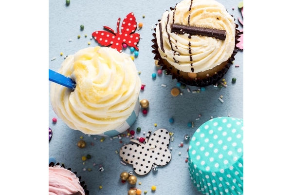 Image Colorful cupcakes with creamy frosting, sprinkles, and decorative paper butterflies on a light blue background